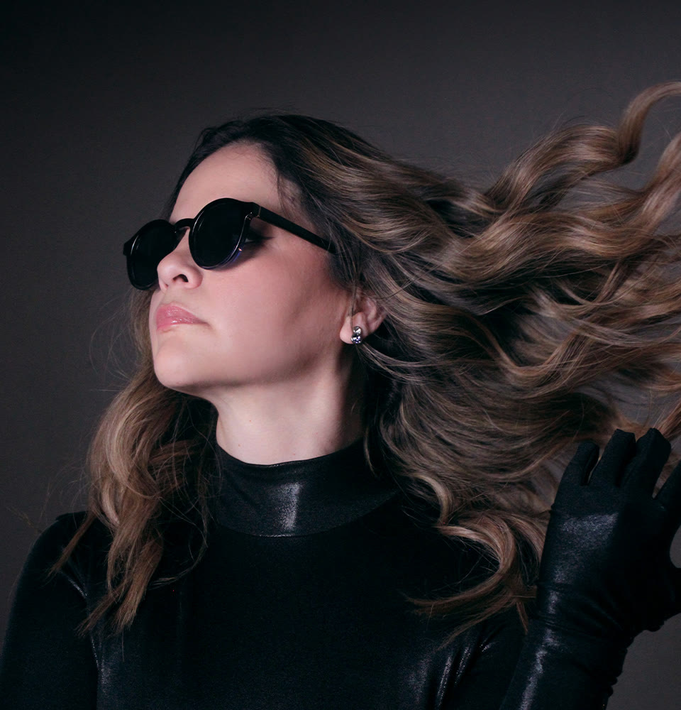 Alexa Zuart con lentes oscuros y el cabello en movimiento